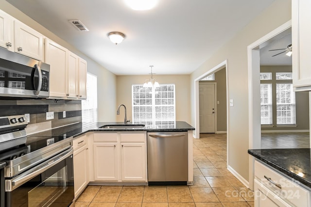 kitchen with kitchen peninsula, appliances with stainless steel finishes, sink, and plenty of natural light