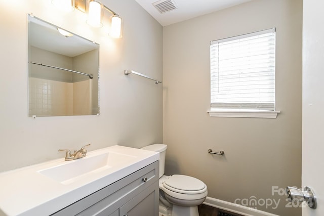 bathroom with a shower, vanity, and toilet