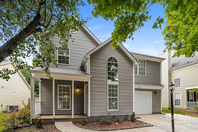 view of front of home featuring a garage, central AC unit, and covered porch