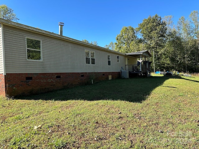 rear view of house featuring central air condition unit and a lawn