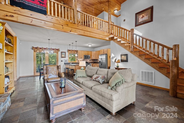 living room with a high ceiling, a notable chandelier, and wood ceiling