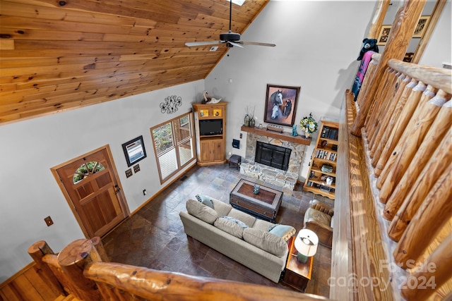 living room featuring a skylight, a fireplace, wood ceiling, ceiling fan, and high vaulted ceiling