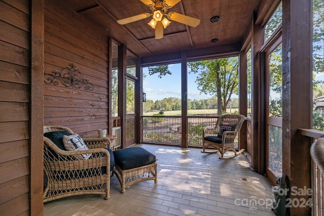 sunroom / solarium with wood ceiling, a healthy amount of sunlight, and ceiling fan