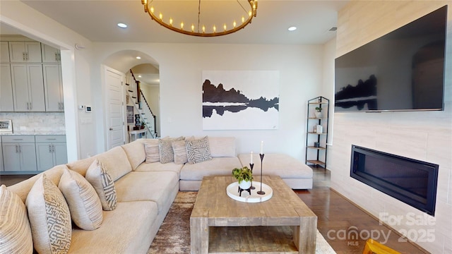 living room featuring dark hardwood / wood-style flooring, a fireplace, and a chandelier