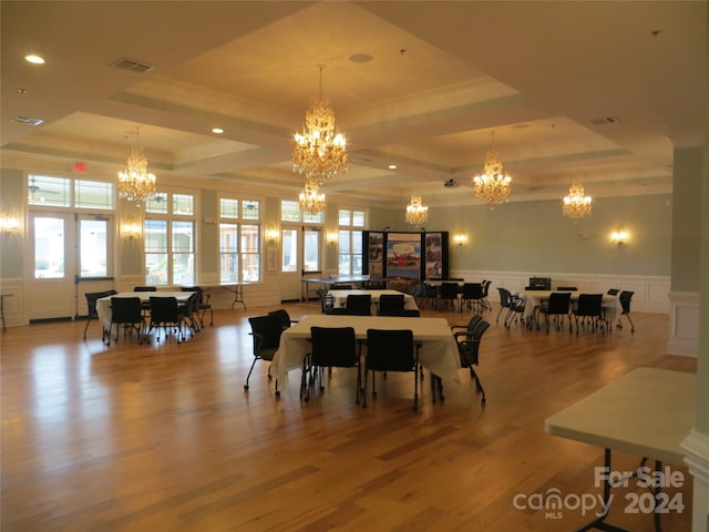 dining room with a raised ceiling, crown molding, and light hardwood / wood-style floors