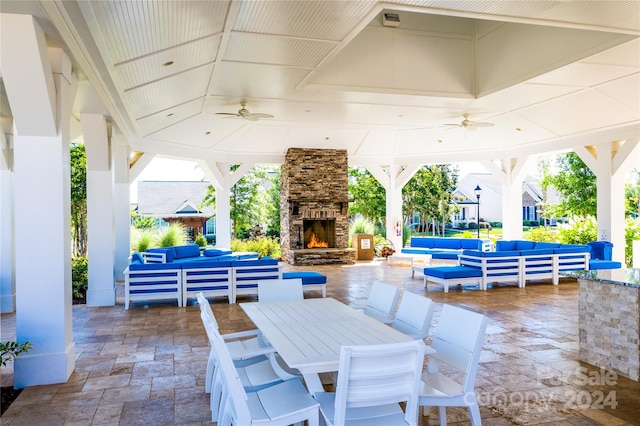 view of patio featuring a gazebo, an outdoor living space with a fireplace, and ceiling fan