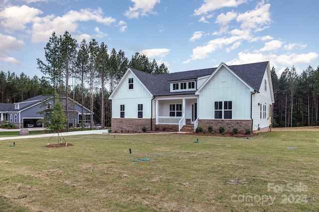 modern farmhouse style home with a porch and a front lawn