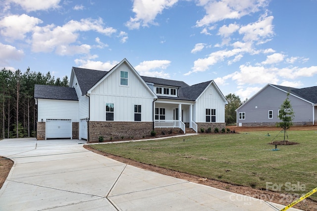 modern inspired farmhouse featuring a garage, a front lawn, and covered porch