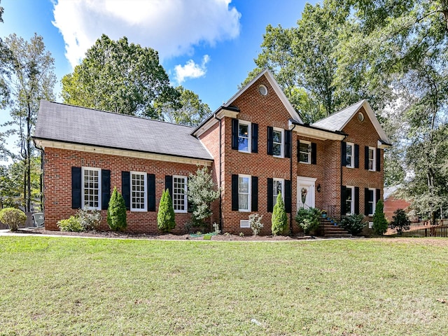 colonial home featuring a front lawn