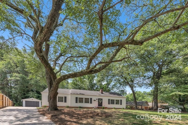 ranch-style house featuring a garage and an outbuilding