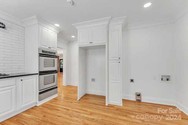 kitchen with stainless steel double oven, light wood-type flooring, crown molding, and white cabinetry