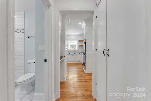 hall featuring light wood-type flooring and sink