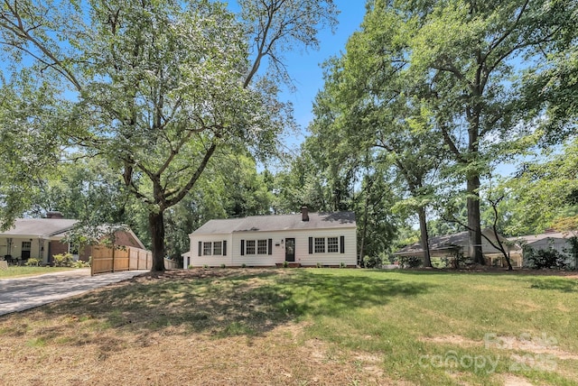 ranch-style home with a front yard and fence