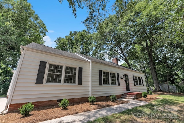 view of front of property with crawl space, a chimney, and fence