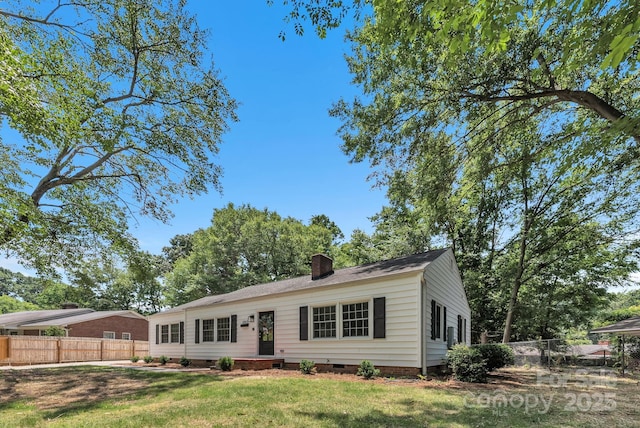 ranch-style home featuring crawl space, a chimney, fence, and a front yard