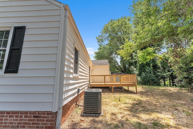 view of yard featuring a deck and central air condition unit