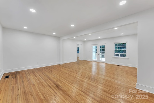 unfurnished living room with light wood-style floors, recessed lighting, visible vents, and french doors