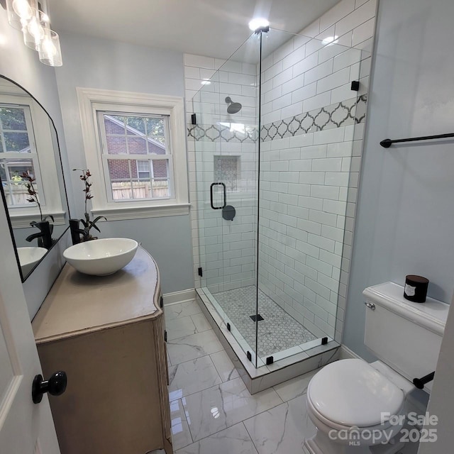 bathroom with baseboards, toilet, marble finish floor, vanity, and a shower stall