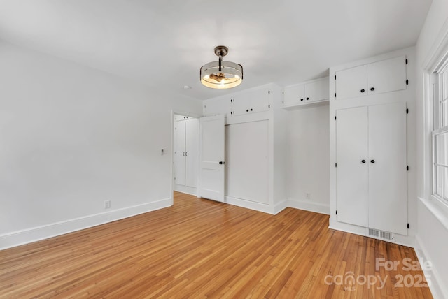 interior space featuring light wood finished floors, visible vents, and baseboards