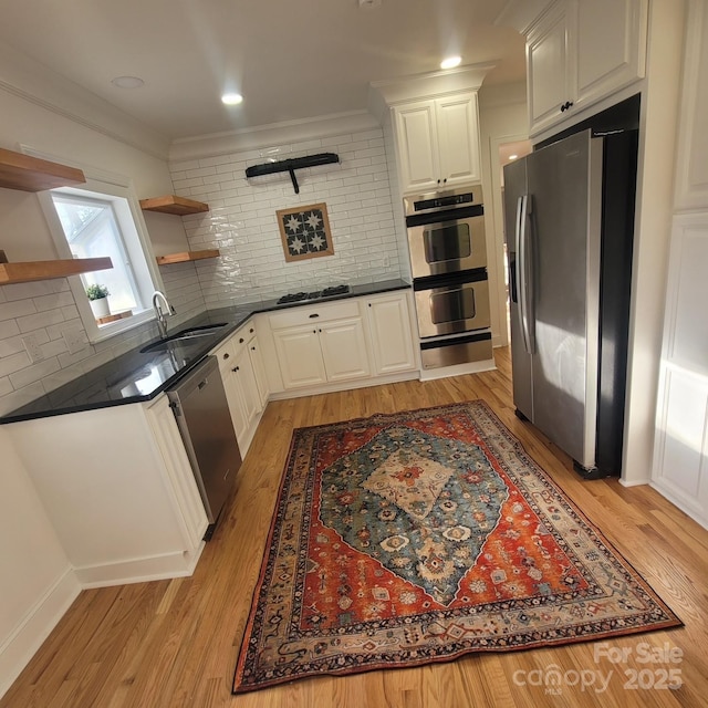 kitchen featuring a sink, white cabinetry, appliances with stainless steel finishes, open shelves, and dark countertops