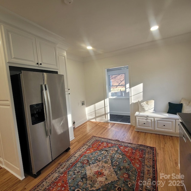 kitchen featuring light wood-style floors, stainless steel fridge, and white cabinets