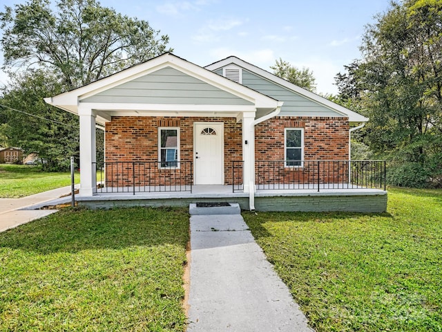 bungalow with covered porch and a front yard