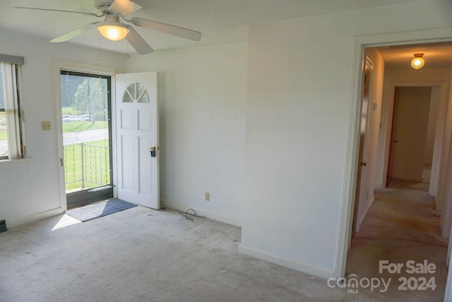 foyer with ceiling fan and light colored carpet