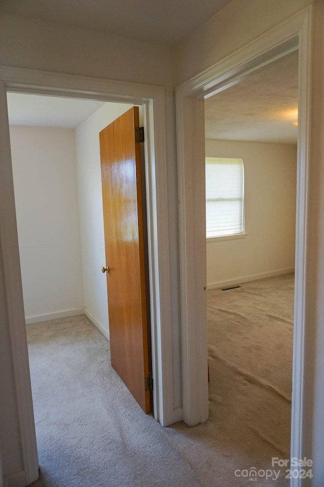 hallway with light colored carpet