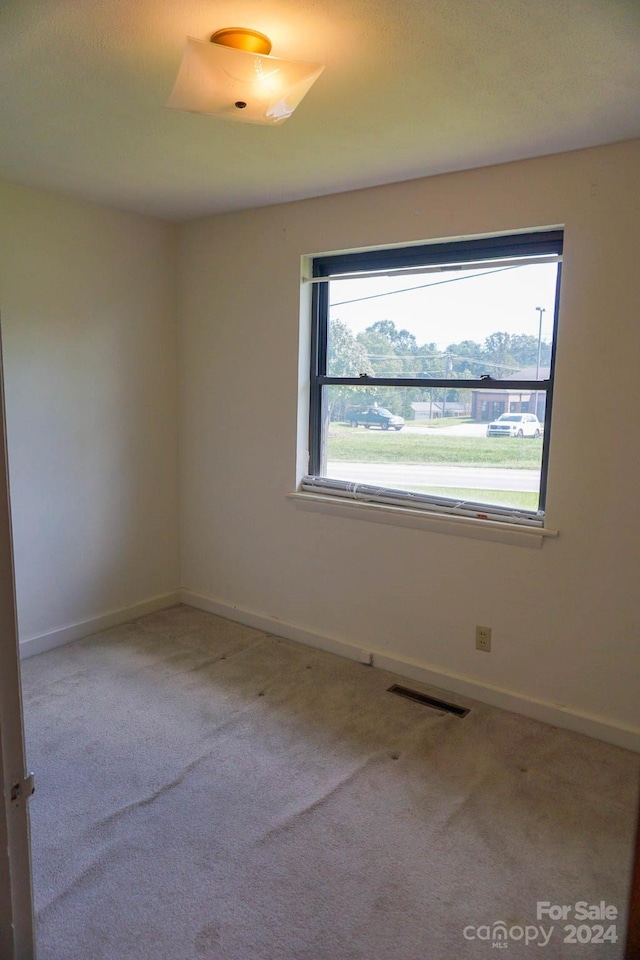 unfurnished room featuring light carpet