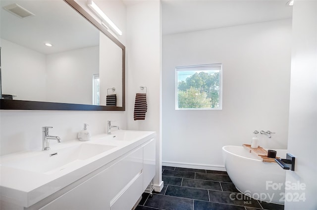 bathroom featuring vanity, a tub to relax in, and tile patterned flooring