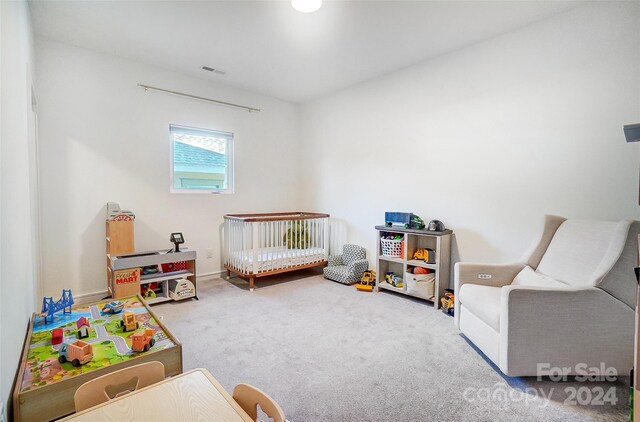 carpeted bedroom featuring a crib