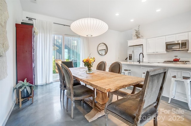 dining room featuring finished concrete floors, recessed lighting, and baseboards