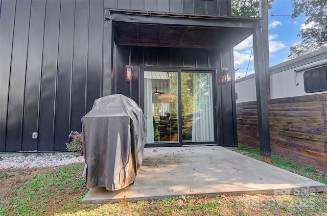 exterior space with board and batten siding, a patio area, and fence