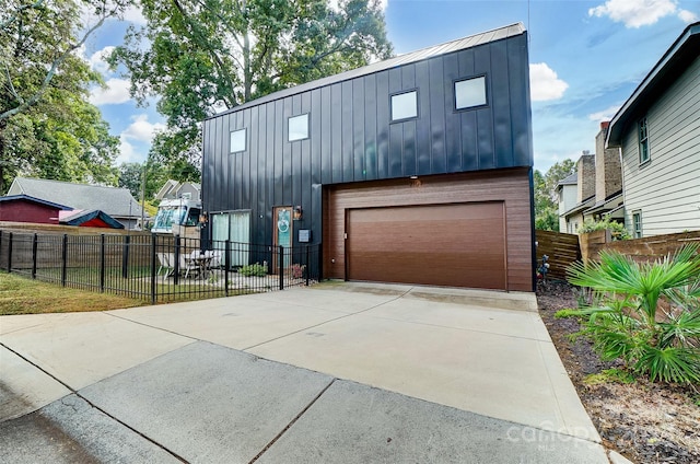 view of front of home featuring a garage, fence, driveway, and board and batten siding