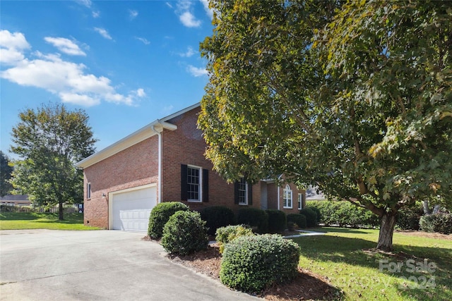 view of side of home featuring a garage and a yard