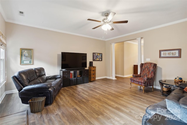 living room with ceiling fan, ornamental molding, light wood-type flooring, and decorative columns