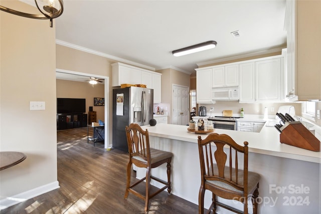 kitchen with a breakfast bar, dark hardwood / wood-style floors, white cabinetry, kitchen peninsula, and appliances with stainless steel finishes