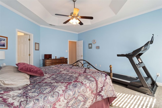 carpeted bedroom featuring ceiling fan, a raised ceiling, and crown molding