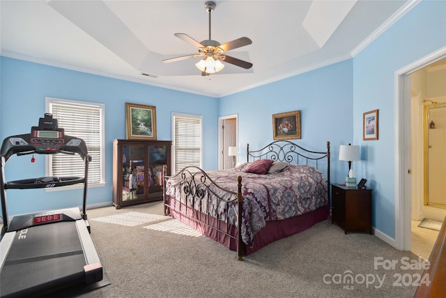 carpeted bedroom with connected bathroom, ceiling fan, and multiple windows