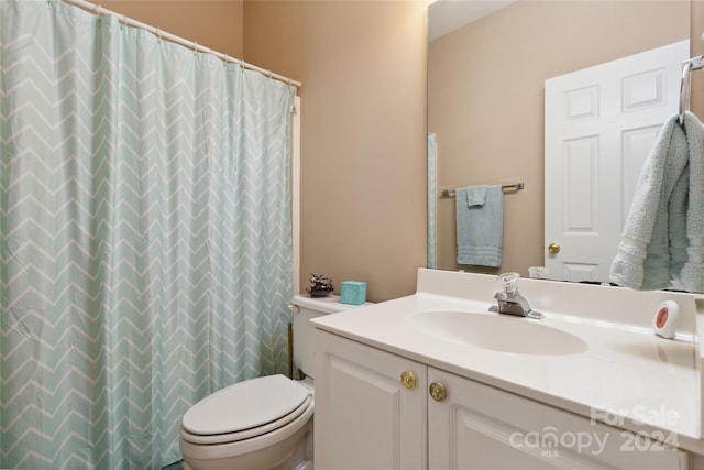 bathroom with vanity, toilet, and a shower with curtain