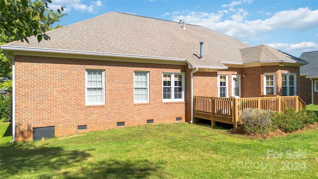 rear view of house with a lawn and a deck