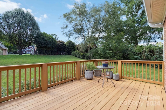 wooden terrace featuring a lawn