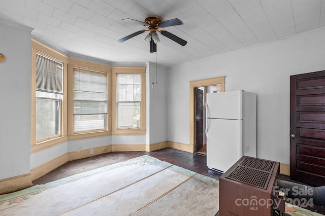 interior space featuring crown molding, ceiling fan, and dark wood-type flooring