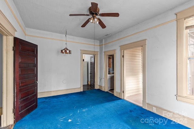 empty room featuring dark carpet and ceiling fan