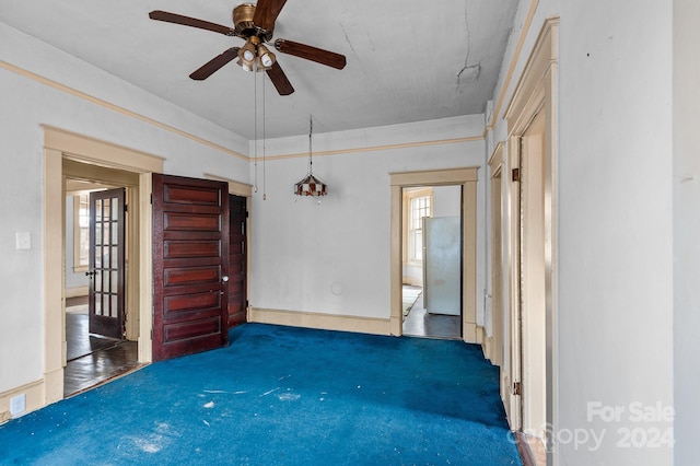 unfurnished room featuring dark carpet and ceiling fan