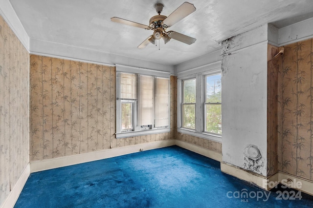 spare room with dark colored carpet and ceiling fan