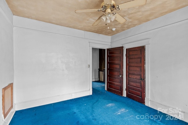 unfurnished bedroom featuring ceiling fan, a closet, and dark colored carpet