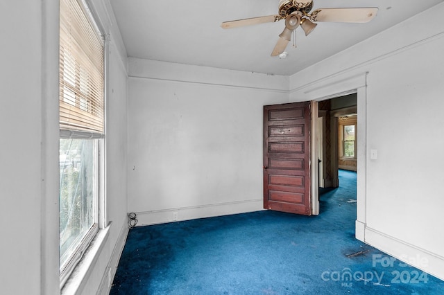 carpeted spare room featuring ceiling fan