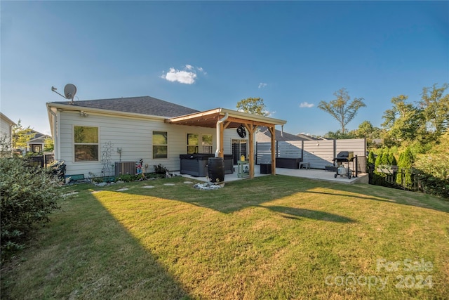 rear view of house featuring cooling unit, a lawn, and a patio area