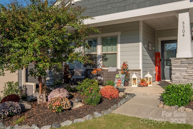 property entrance with stone siding and covered porch